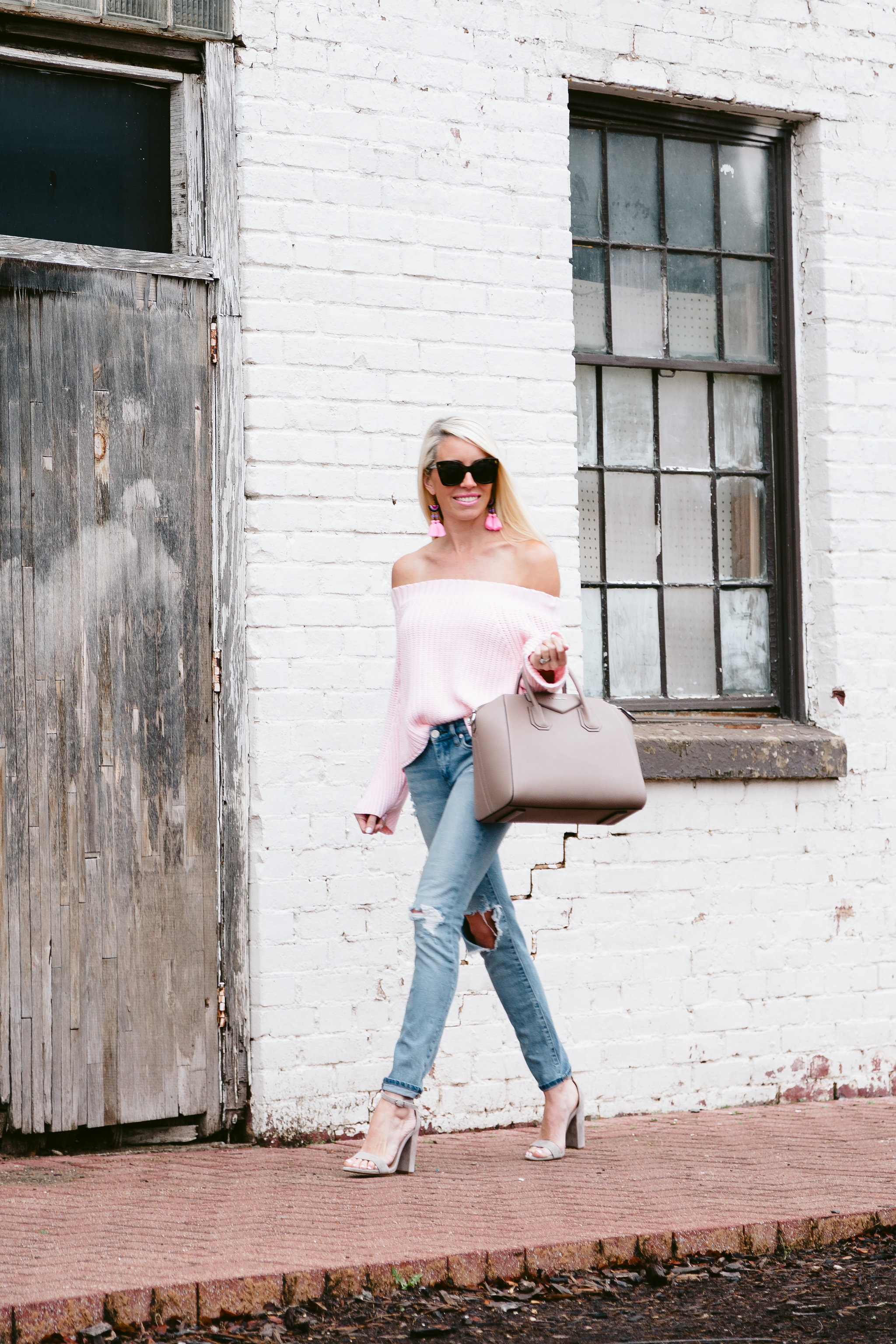 Pink OTS sweater worn half tucked with distressed skinny jeans