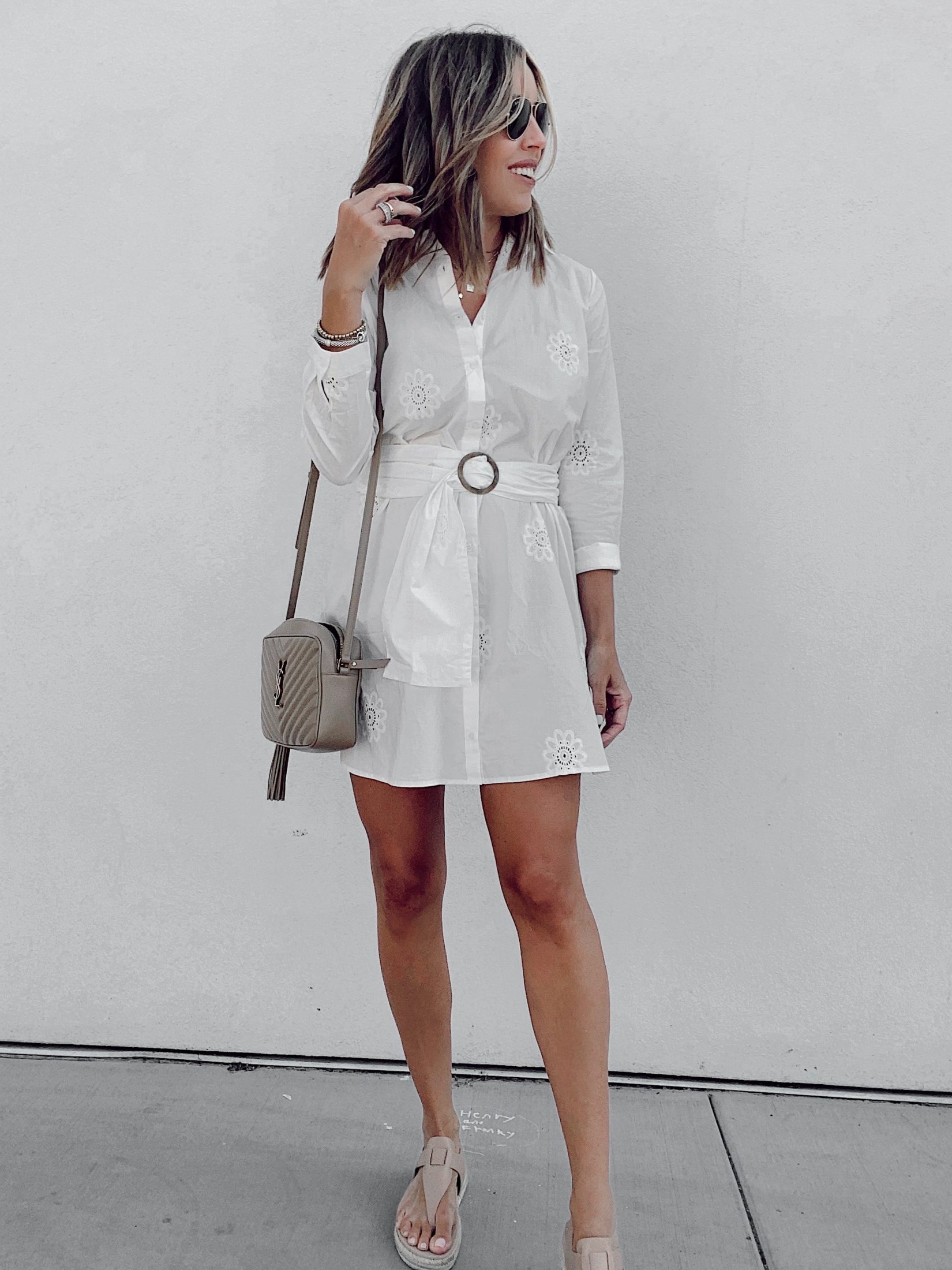 fashion blogger wearing white summer eyelet mini dress with belt