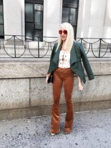 green leather jacket, brown suede flared pants, lace-up body suit, mirrored sunglasses