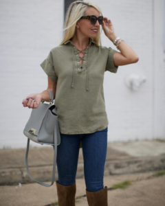 olive green lace up top, lace up top trends for fall, medium wash skinny jeans, grey studded handbag
