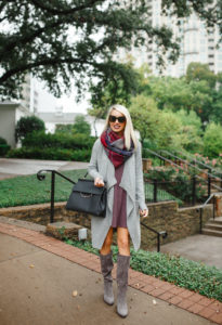 multicolored plaid infinity scarf, oversized grey drapey cardigan, knee high flat grey boots, above the knee cowl neck dress