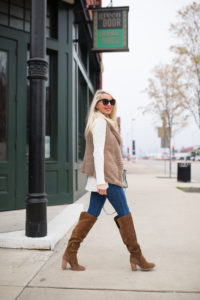 ivory high low sweater, whiskey colored suede boots, plunging v-neck pullover, the perfect skinny jeans, light brown fuzzy vest