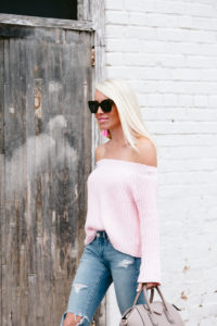 pink off the shoulder sweater, distressed skinny jeans, open toe suede sandals, pink statement earrings