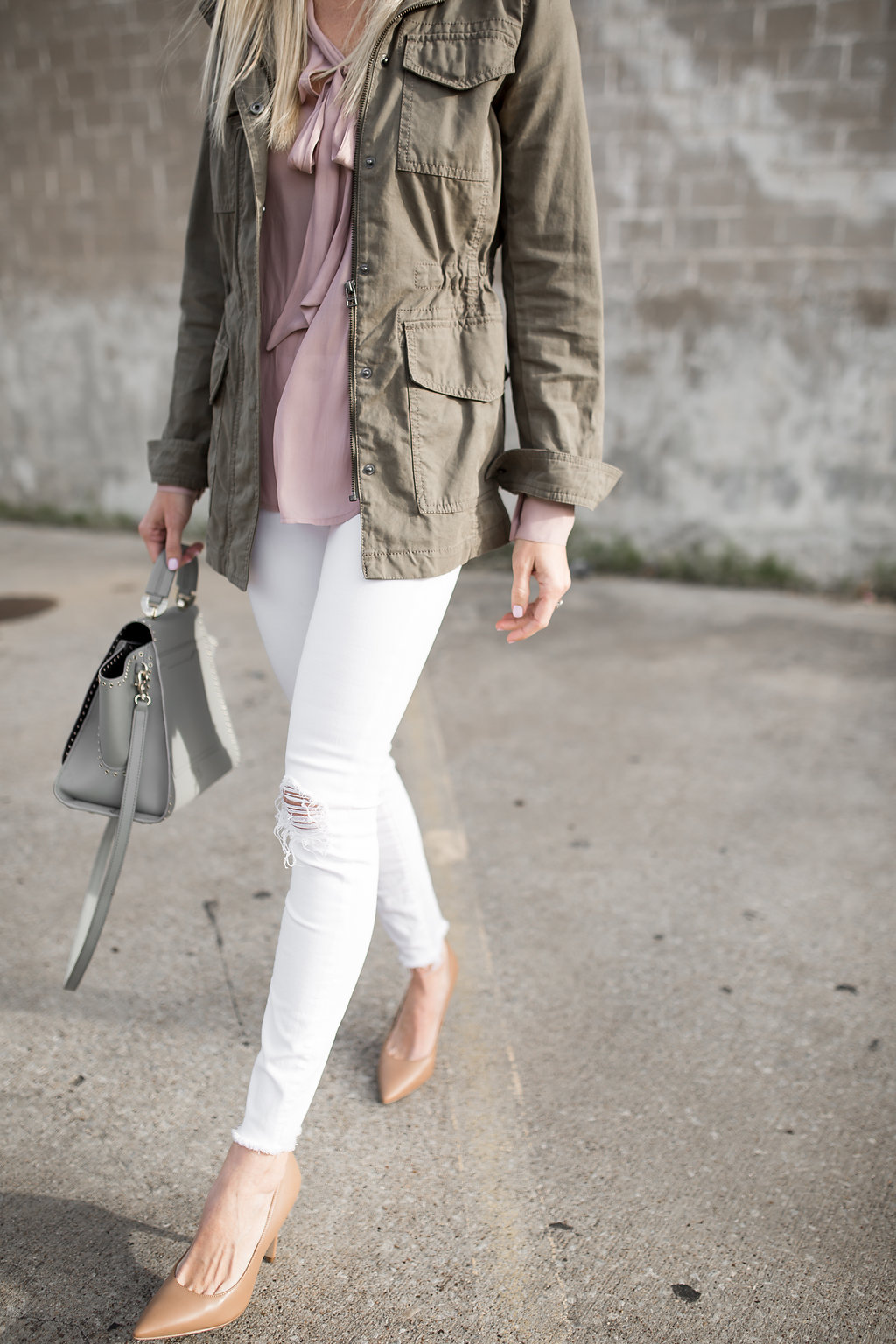 blush bow tie blouse worn with white denim and a military jacket