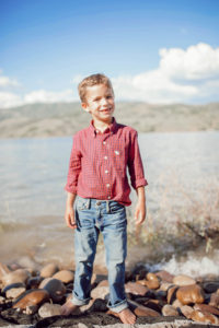 fashion blogger kid wearing preppy red check long sleeve and classic jeans