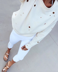 fashion blogger wearing workout athleisure outfit featuring alo grommet pullover with alo white high waist prism capri