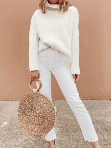 jaime shrayber wearing Walmart ivory waffle knit turtleneck sweater with white ankle jeans and carrying round straw bag