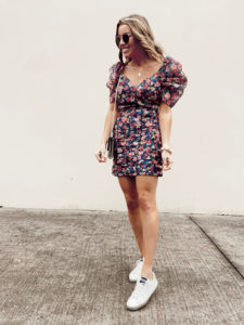 fashion blogger wearing spring mini floral dress with golden goose white sneakers - date night outfit ideas