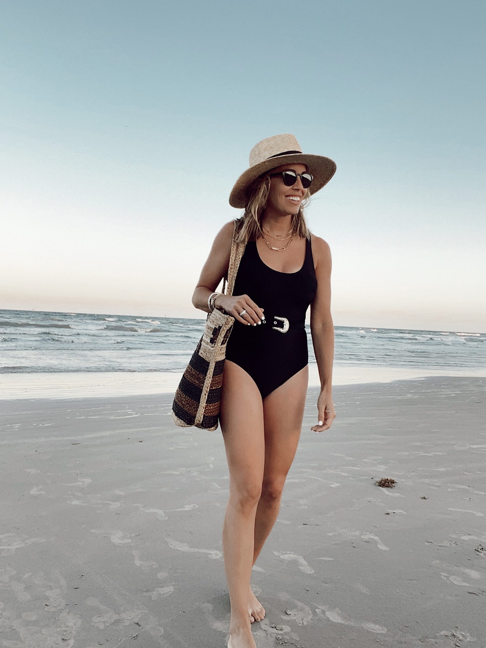 jaime shrayber wearing belted one piece black swimsuit at cinnamon shores beach