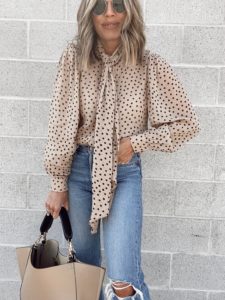 jaime shrayber wearing ganni polka dot tie neck blouse with Levi’s wedgie icon fit ripped straight leg jeans