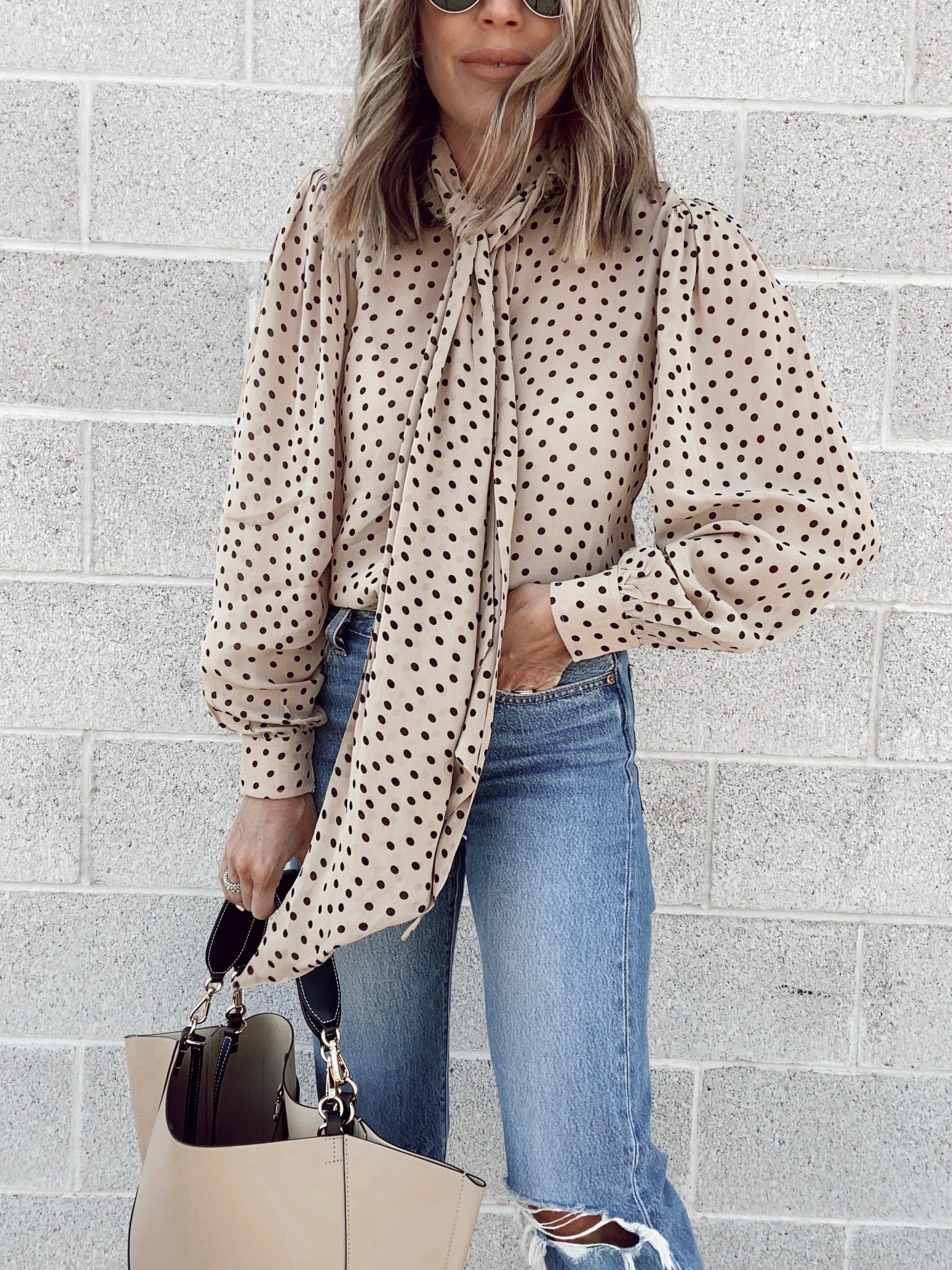 fashion blogger wearing ganni polka dot tie neck blouse with Levi’s wedgie icon fit ripped straight leg jeans