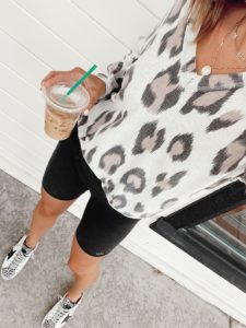 black alo biker shorts with leopard print sweater and golden goose sneakers
