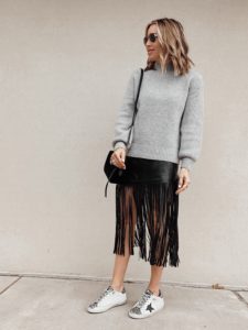 jaime shrayber wearing grey sweater with black faux leather fringe midi skirt