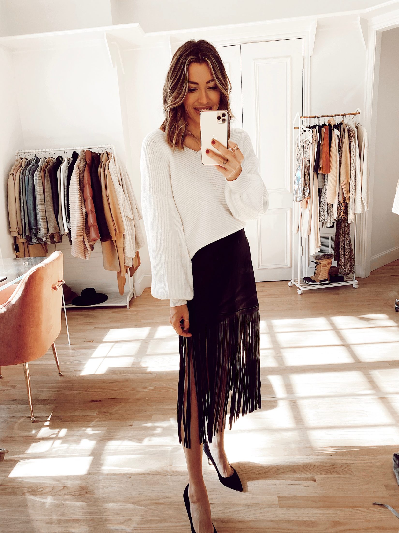 holiday outfit idea with white sweater and black fringe midi skirt and heels